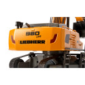 Excavadora teledirigida Liebherr R980 RC a escala 1:32 con brazo móvil y chasis de orugas.