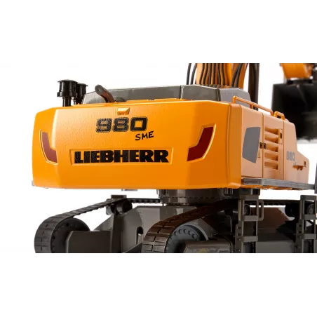Excavadora teledirigida Liebherr R980 RC a escala 1:32 con brazo móvil y chasis de orugas.