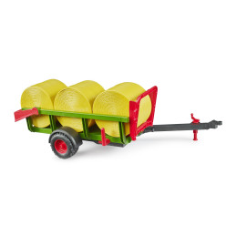 Recolector de pacas de juguete Bruder a escala 1:16 con tres pacas redondas.